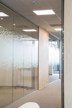 an empty office with glass walls and chairs