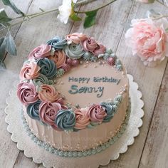 a birthday cake decorated with flowers on a table