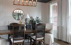 a dining room table with chairs and a mirror on the wall