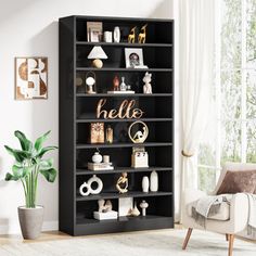 a black bookcase with hello written on the front and shelves above it in a living room