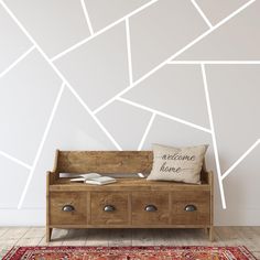 a wooden bench sitting in front of a wall with white lines painted on the walls