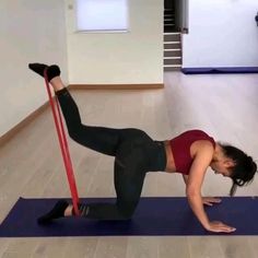 a woman is doing an exercise on a mat with a pole in her hand and one leg up