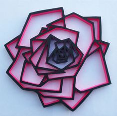 a bunch of cut out pieces of paper in the shape of a flower on a white surface