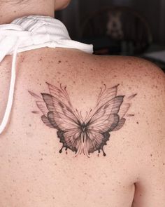 a woman with a butterfly tattoo on her back