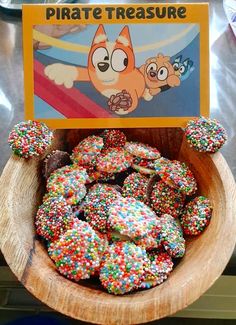 there is a bowl full of donuts with sprinkles on it and a sign that says pirate treasure