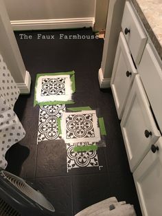 a bathroom with black and white tile on the floor next to an ironing board