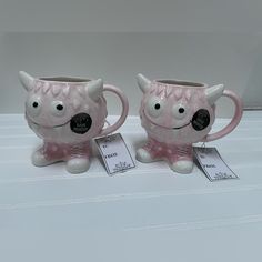 two pink mugs sitting on top of a table