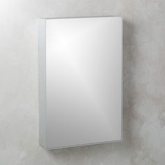 a bathroom mirror mounted to the side of a wall