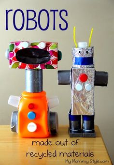 two robots made out of recycled materials sitting on a table