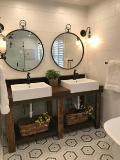 a bathroom with two sinks and mirrors on the wall