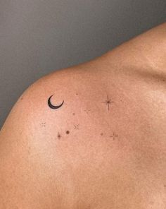 the back of a man's shoulder with stars and a crescent tattoo