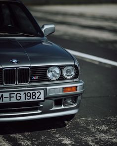 a silver bmw is parked on the street