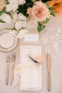 the table is set with silverware, flowers and napkins for an elegant wedding reception