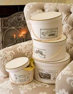 three buckets are stacked on top of each other in front of a fireplace with candles