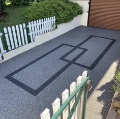 a driveway with a fence and gate in front of it