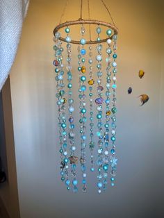 a wind chime hanging from the ceiling with blue beads and other items on it