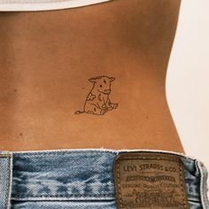 a small tattoo on the back of a woman's stomach shows an image of a dog