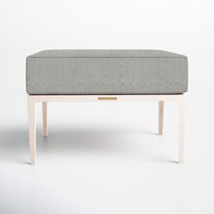 a bench made out of wood and upholstered with fabric on the top, sitting in front of a white background