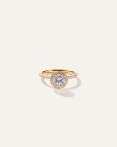 a yellow gold ring with a round diamond in the center