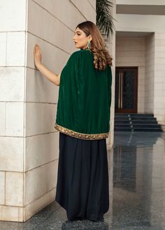 Emerald green velvet cape handworked with dabka, tilla and zardozi with accents of jamawar. Paired with black flared pants and an inner slip. A very chic and trendy outfit for the winter weddings or festivities. (Includes cape and inner slip) Green Cape Sleeves Sets For Eid, Green Cape Sleeve Sets For Eid, Festive Green Palazzo Set With Cape Sleeves, Traditional Sharara With Dabka Work And Cape Sleeves, Bollywood Green Set With Cape Sleeves, Festive Sharara With Dabka Work And Cape Sleeves, Traditional Kurta With Cape Sleeves For Party, Traditional Party Kurta With Cape Sleeves, Traditional Festive Palazzo Set With Cape