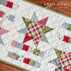 a quilted table runner with red, green and white stars on it's side