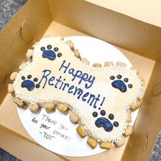 a birthday cake in the shape of a dog's bone with paw prints on it