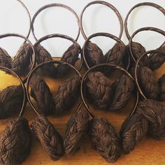 several balls of yarn sitting on top of a wooden table next to metal hoop holders