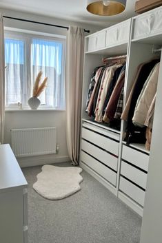 a bedroom with white closets and carpeted flooring next to a large window