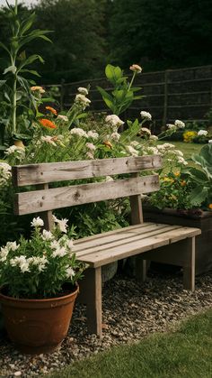 a wooden bench sitting in the middle of a garden filled with lots of flowers and plants