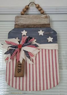 an american flag bag hanging from the side of a window with a tag attached to it