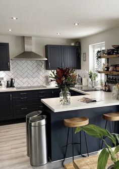 a kitchen filled with lots of counter space and wooden stools next to an island