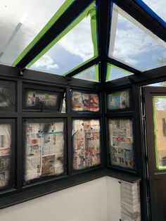 the inside of a building with newspaper on it's windows and sky in the background