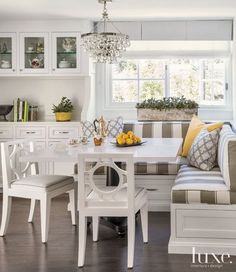 a dining room table and bench in front of a window