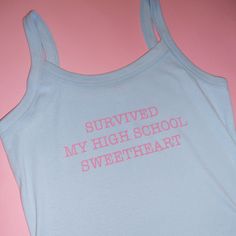 -Tank says, “SURVIVED MY HIGH SCHOOL SWEETHEART” -Bella + Canvas blank -Stretch fit with a slight crop -Screen-printed by hand meaning each tee is unique, so differences may occur! -Made-to-Order item *takes 2-3 weeks to ship, if there are further delays we will email you* Fitted Graphic Print Cute Tank Top, Cute Sleeveless Streetwear Tops, Trendy Graphic Print Camisole Tank Top, Trendy Camisole Tank Top With Graphic Print, Casual Graphic Print Cami Tank Top, Fitted Cotton Tank Top With Slogan, Cute Cotton Racerback Tank Top, Y2k Cotton Tank Camisole, Y2k Style Cotton Tank Camisole