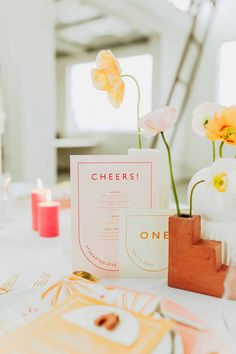 the table is set with pink and yellow flowers