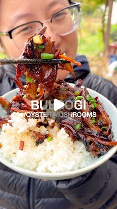 a person holding up a plate of food with chopsticks in their mouth and rice on the other side