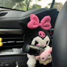 the stuffed animal is in the car with its head on the steering wheel and it's pink ears