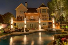 a large house with lights around the pool