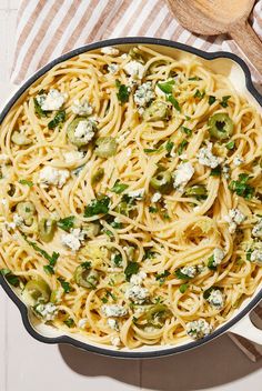 a pan filled with pasta and vegetables on top of a table