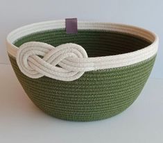 a green and white basket with a knot on it