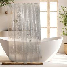 a white bathtub sitting next to a window in a bathroom with plants on the floor