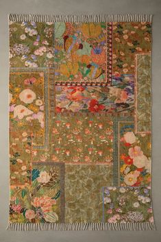 an old piece of cloth with flowers and birds on it, hanging from the wall