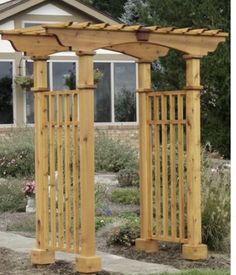 a wooden garden arbor in front of a house