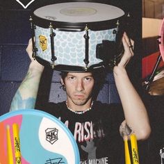 a man holding up a drum in front of his face