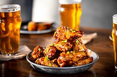 a plate full of food next to two glasses of beer