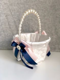 a white basket with blue ribbon and pearls