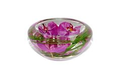 a glass bowl filled with pink flowers on top of a table