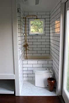 a white toilet sitting in a bathroom next to a window