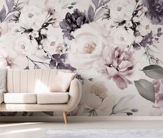 a white couch sitting in front of a floral wallpaper