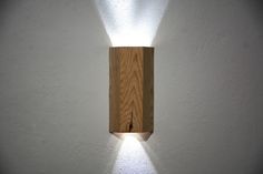 a light that is on the side of a wall with a wooden object in it